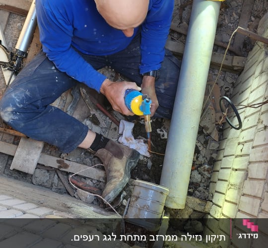 אדם עובד על גג עם כלי עבודה וצינורות